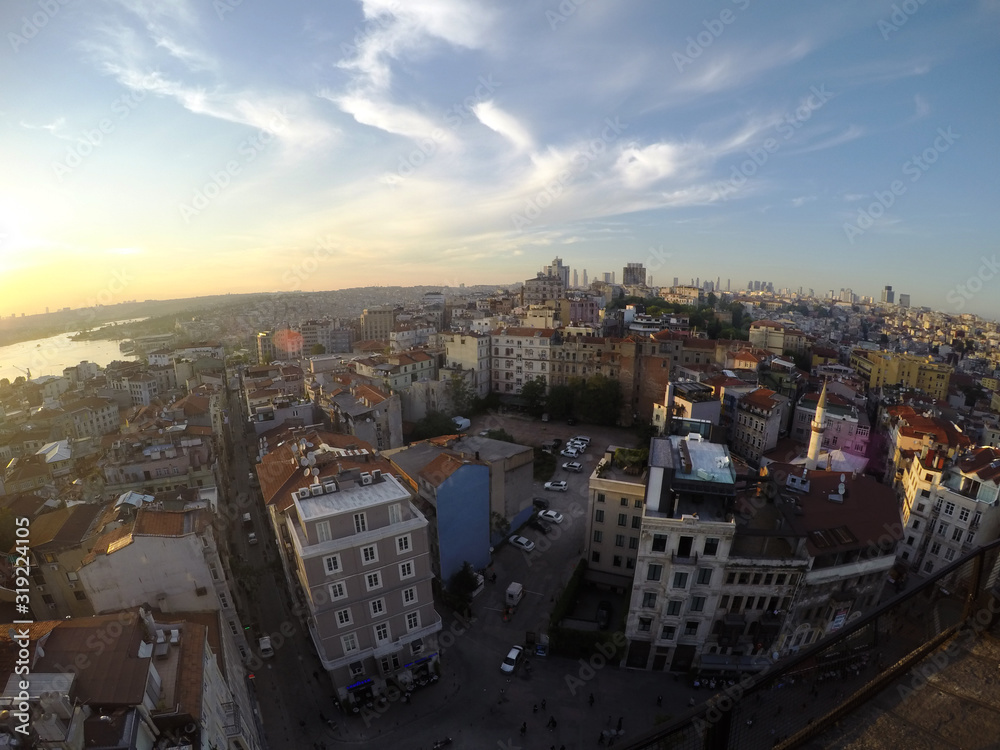 Istanbul panoramic view from Galata tower top at sunset, buildings cars and roads under the blue sky