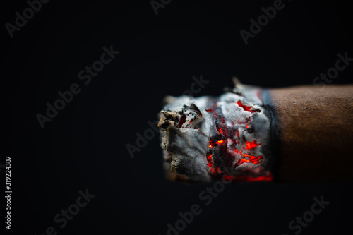 Zigarre/Cigarillo glühend Nahaufnahme Makro vor schwarzem Hintergrund photo