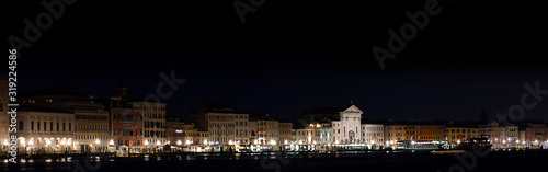 Long horizontal BANNER.Cityscape of Venice at night on black. The city lights punctuate the Venetian night.