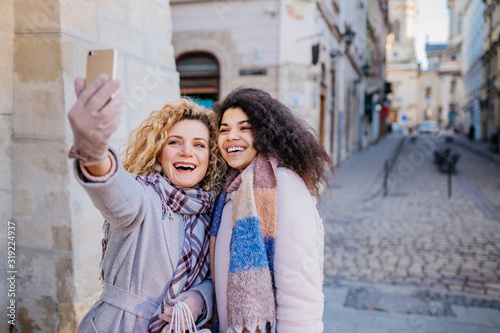 People, friends, teens and friendship concept - happy smiling pretty teenage girls taking selfie.close-up lifestyle portrait of young best friends girls having fun together.Winter fashion.