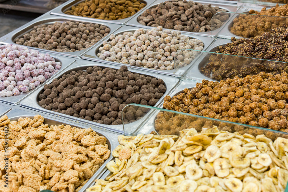 View of Sheet Pans with Nuts, On the market are varieties of nuts in azure dried bananas.