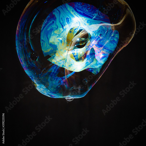 Colorful creative amorphous soap bubble floating with a black background © Colozio