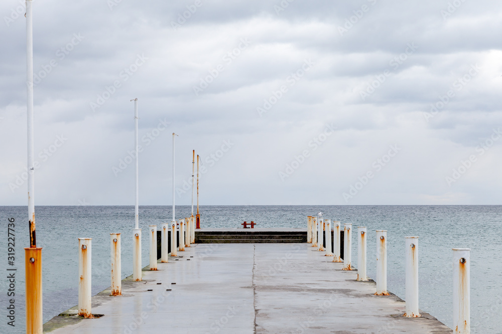 Abandoned concrete sea pier extending far into the sea