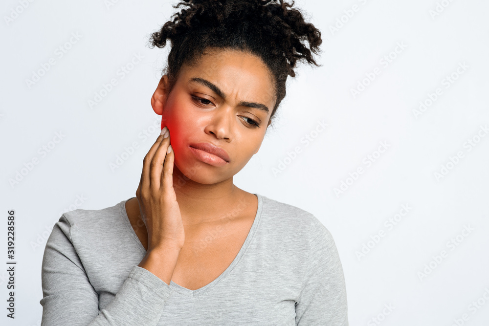 Woman suffering from inflamed gums, grey background