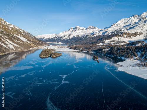 Aerial image of the Chaviolas and Chaste islets on the frozen lake of Silsersee in St. Moritz, Switzerland photo