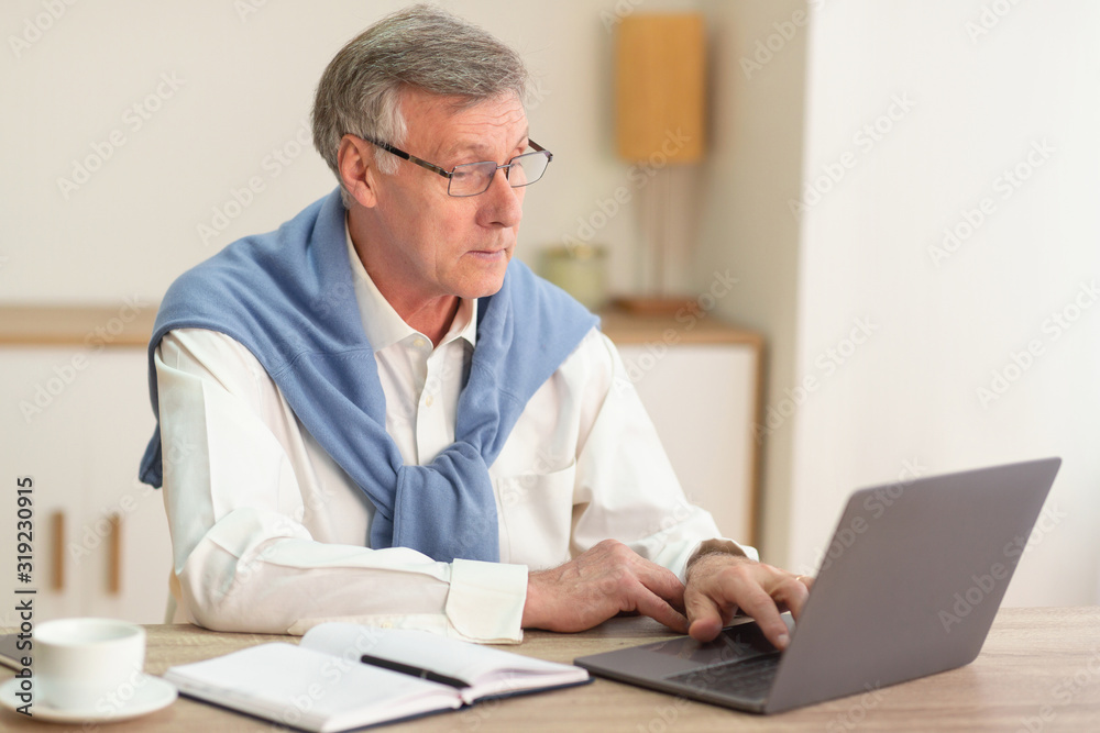 Serious Gentleman Using Laptop Typing Business Report In Office