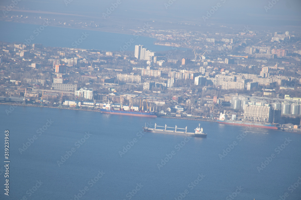 Aerial view of the city. Foggy day, sunny weather and blue sky. 400 meters above the ground. Small houses and river view. Winter  sky.