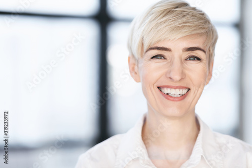 Middle Aged Businesswoman Smiling To Camera Posing In Modern Office