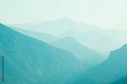 Skyline of Turquoise mountains in a misty dawn morning