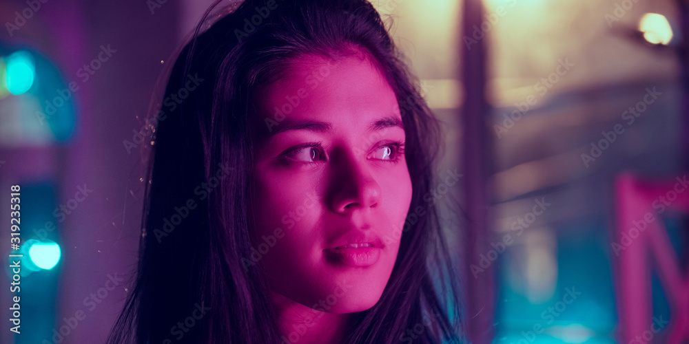Cinematic close up portrait of stylish woman in neon lighted interior. Toned like cinema effects in purple-blue. Caucasian female model looks calm and delighted in colorful lights indoors. Flyer. Cinematic close up portrait of stylish woman in neon lighted interior. Toned like cinema effects in purple-blue. Caucasian female model looks calm and delighted in colorful lights indoors. Flyer.
