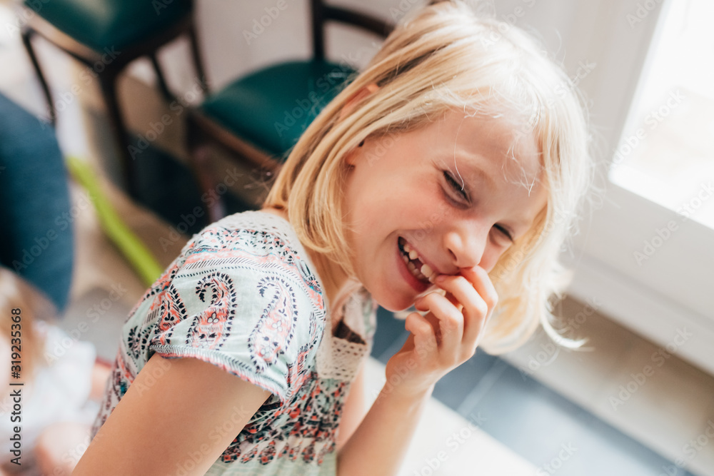 Young beautiful female child indoor at home looking camera laughing Young beautiful female child indoor at home looking camera laughing