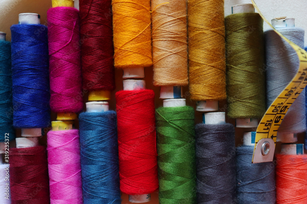 colorful spools of sewing thread on a white background colorful spools of sewing thread on a white background