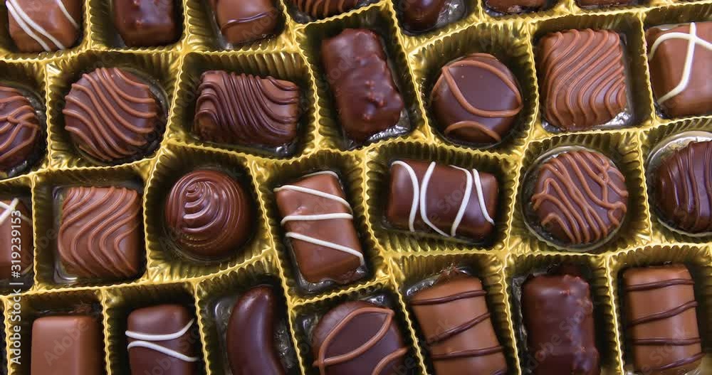 Selection of pralines with milk and dark chocolate in box. Loving chocolate and sweets concept. Dolly shot 4k