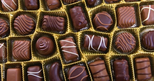 Selection of pralines with milk and dark chocolate in box. Loving chocolate and sweets concept. Dolly shot 4k