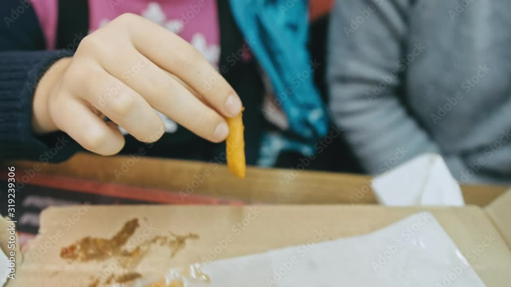 Child eat pizza and french fry potato. Close up of young girl woman eating pizza and chewing in outdoor restaurant. Kid children hands taking pieces slices of hot tasty italian pizza from open box. Child eat pizza and french fry potato. Close up of young girl woman eating pizza and chewing in outdoor restaurant. Kid children hands taking pieces slices of hot tasty italian pizza from open box.