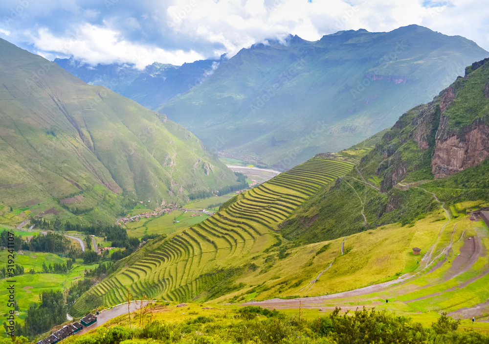 Green valley with farming terraces on the hills and mountains on background Green valley with farming terraces on the hills and mountains on background