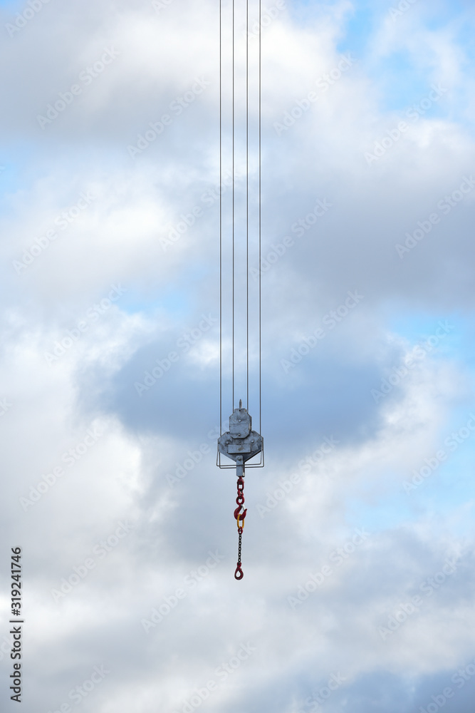 Crane hook hanging over an empty sky suspended in mid air Crane hook hanging over an empty sky suspended in mid air