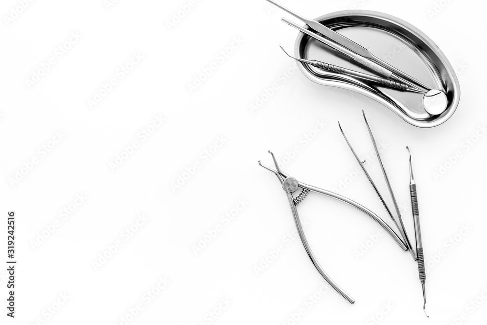 Naklejka premium Stomatological tools in tray on dentist's desk on white background top-down frame copy space