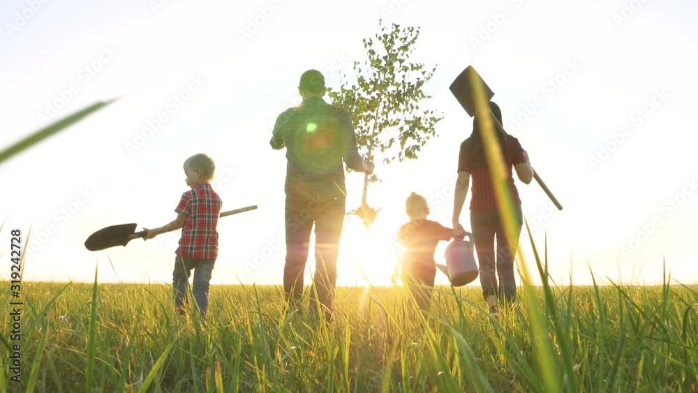 agriculture red neck farming happy family walking agriculture of farmers a silhouette concept slow motion video. mom dad son and daughter walk go children happy family plant and water the tree