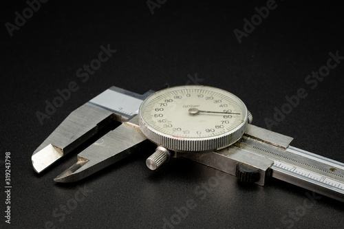 A dial caliper lying on a black background photo