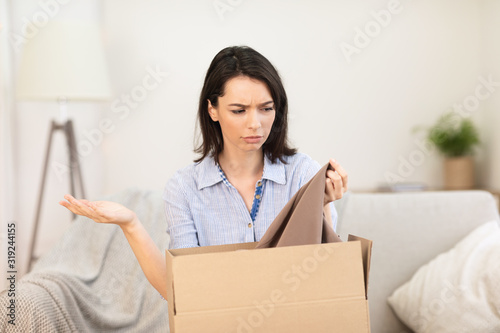 Sad young girl packing clothes for delivery