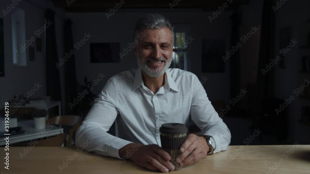 A businessman sitting at the desk indoors in office, working late. A businessman sitting at the desk indoors in office, working late.