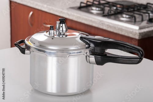 Double valve pressure cooker on white background.