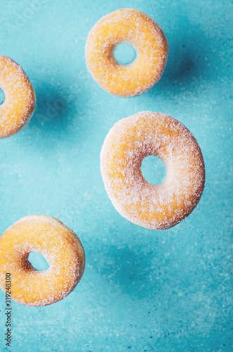 Donuts on turquoise background. Top view, copy space.