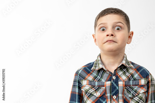 Close up portrait of the surprised, shocked little boy in shirt that looking at the camera, making funny face isolated over white background, copyspace for your text
