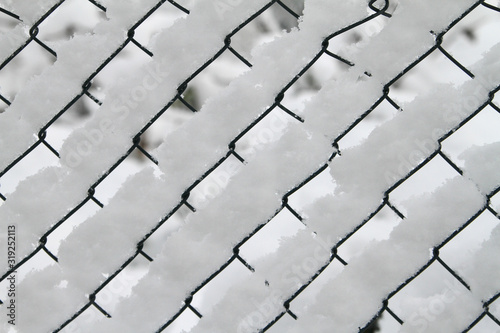 Mesh fence with fresh snow like a white wall