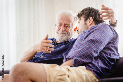 old man serious discussion with younger man indoor, grand father serious talking with his son at home. © Quality Stock Arts