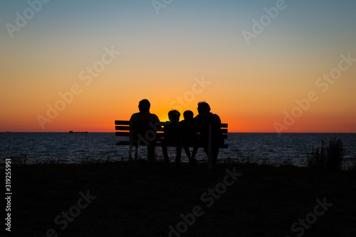 family watching the sunset on the beach