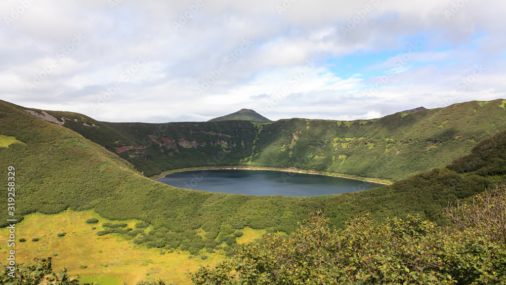Small round lake inside the crater of the extinct volcano. Kamchatka Peninsula, Russia