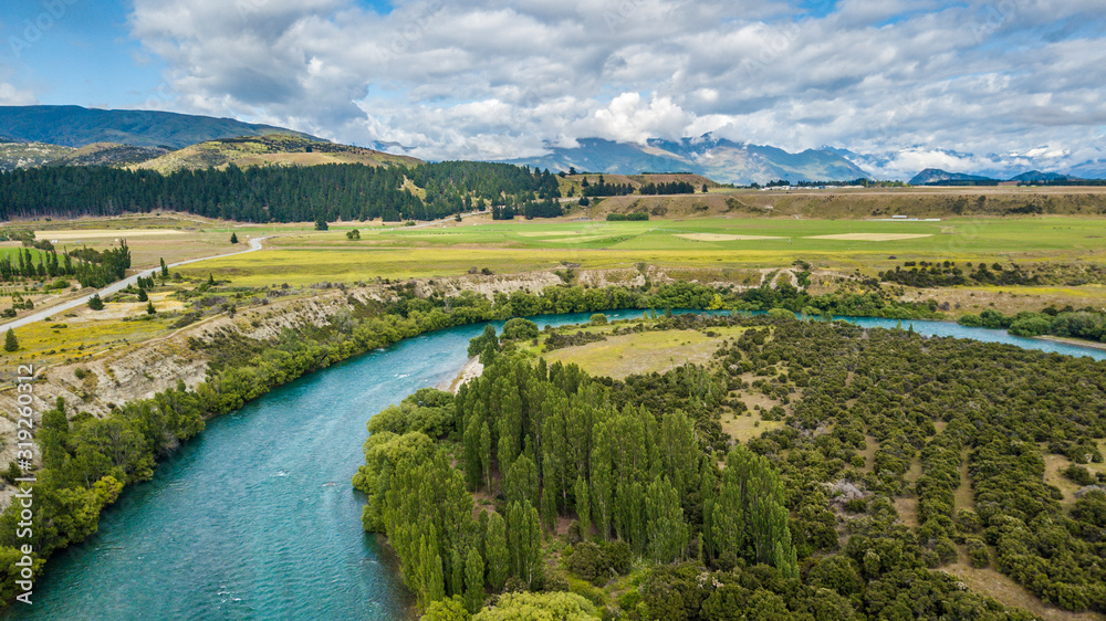 Turquoise river with a green trees and meadows
