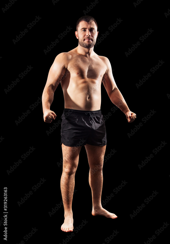 Brutal muscular sportsman standing in black shorts. Brutal muscular sportsman standing in black shorts.