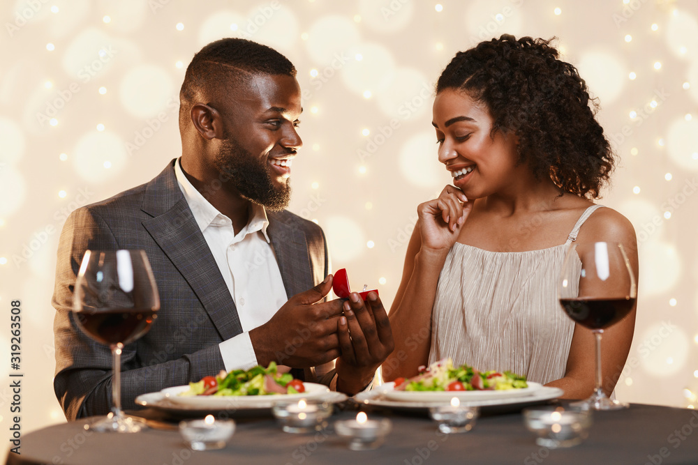 Handsome black man making marriage proposal to his beautiful woman Handsome black man making marriage proposal to his beautiful woman