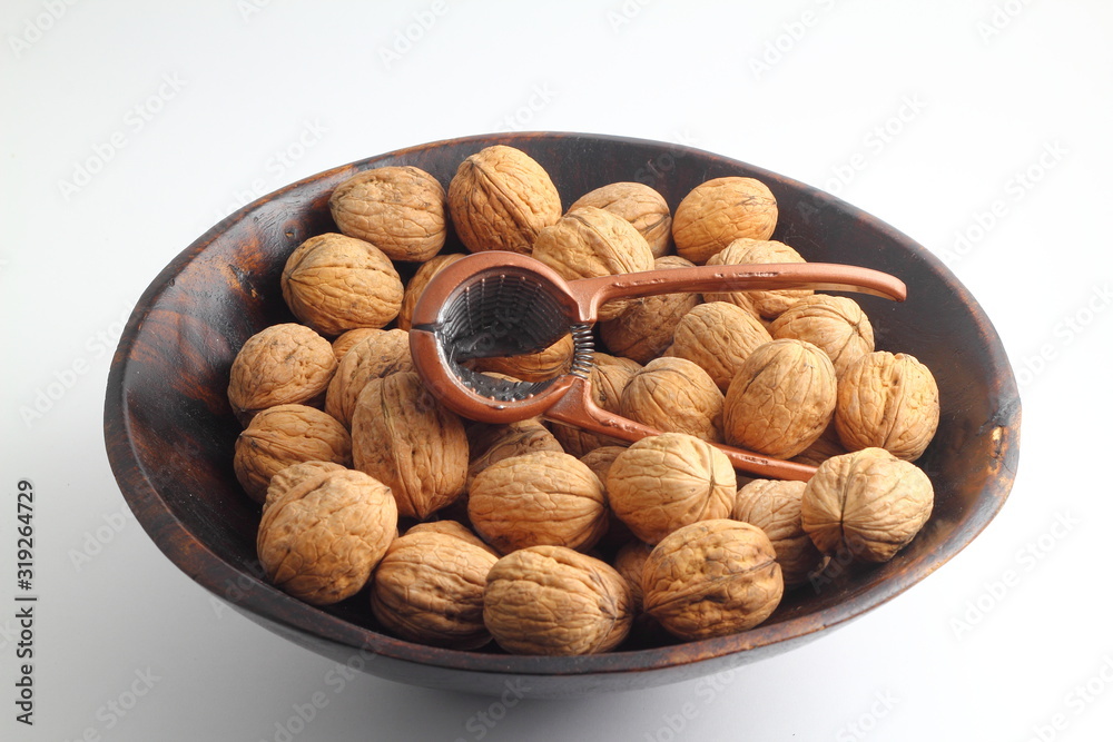 walnuts in a bowl isolated on white background. with nutcracker. walnuts in a bowl isolated on white background. with nutcracker.