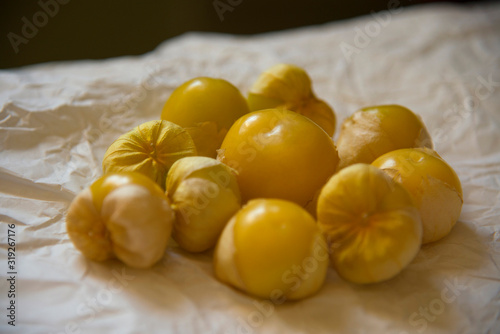 Bunch of fresh matured tomatillo amarylla fruit on wrinkled paper photo