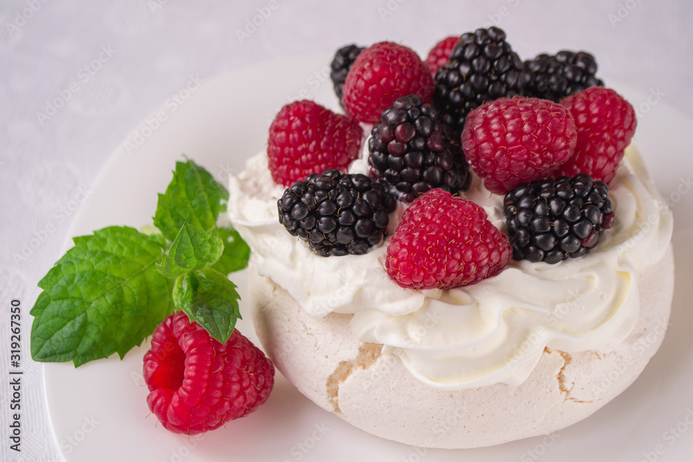 Homemade meringue cake Pavlova with whipped cream, fresh blackberries and raspberries on the top. Delicious dessert. Homemade meringue cake Pavlova with whipped cream, fresh blackberries and raspberries on the top. Delicious dessert.