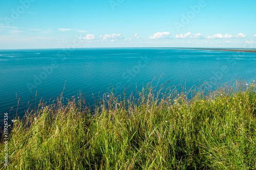 Beautiful landscape scenery cliff meadow  water and blue sky. Cape Andoma  Karelia  Russia