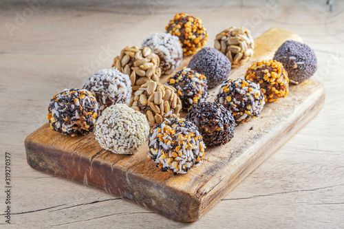 Energy protein balls with healthy ingredients. Home made with dried apricots, dates, plum, almonds, walnuts, sunflower seeds covered with cocoa powder, sesame, coconut flakes
