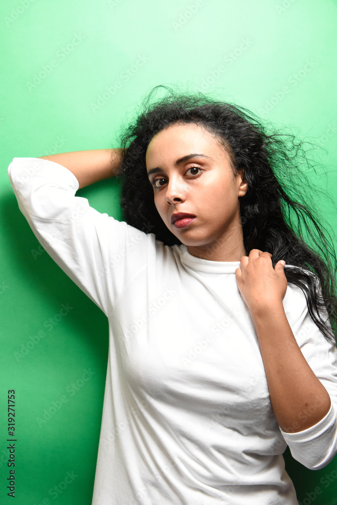 Spectacular middle eastern young woman with her black hair. Indoor photo of wonderful female model on green background. Spectacular middle eastern young woman with her black hair. Indoor photo of wonderful female model on green background.