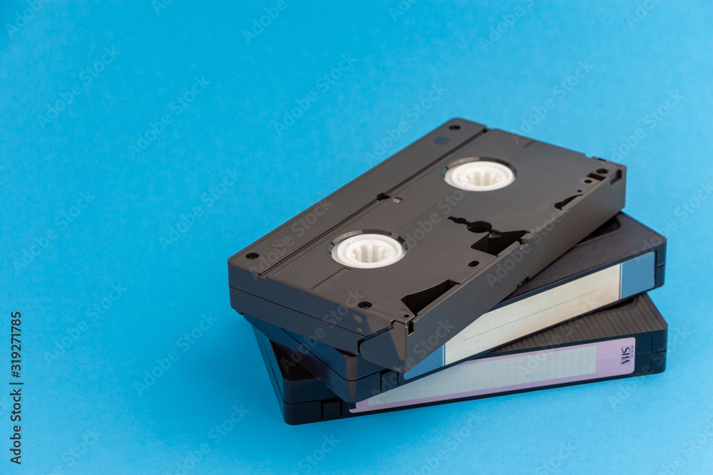 Fototapeta premium Several VHS video cassettes, on a blue background.