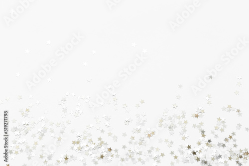 Silver confetti and stars and sparkles on a light background. Top view, flat lay. Copy text. holiday background. For Christmas, New Year, Valentine's Day