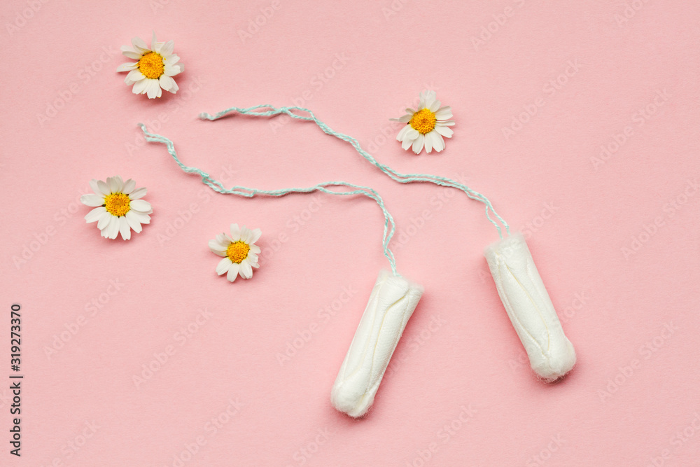 women's health care, cotton tampons with fresh chamomile flowers on pastel rose background, menstruation cycle, intimate hygiene women's health care, cotton tampons with fresh chamomile flowers on pastel rose background, menstruation cycle, intimate hygiene