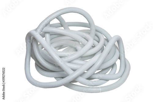 Plastic hose isolated. Close-up of a disorderly bunch of light gray industrial flexible plastic corrugated pipe for electrical cable installations isolated on a white background. Flexible PVC.