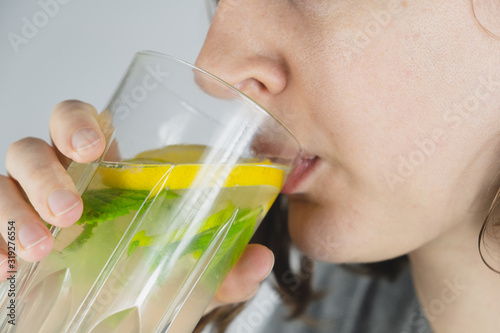 Canvas Print Glass of lemon drink in a human hand