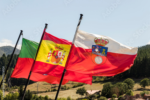 Potes, Spain. Flags of Potes, Spain and Cantabria waving from the Torre del Infantado tower photo