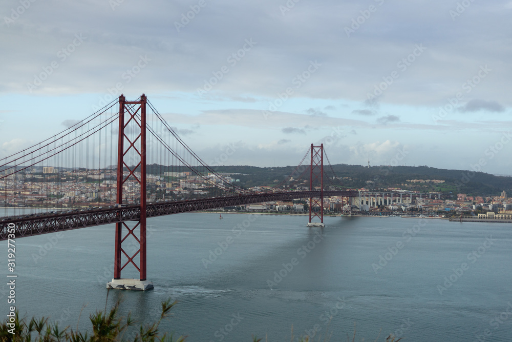 Naklejka premium Most 25 de Abril z Lizboną w tle