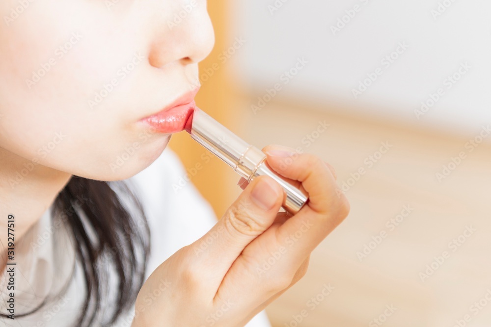 口紅を塗ってメイクする女性 口紅を塗ってメイクする女性